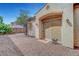 Side home entrance featuring desert landscaping, arched overhang, and covered access at 519 Via Garofano Ave, Henderson, NV 89011