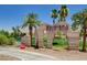 Elegant stone entrance to Chimera Golf Club, surrounded by lush greenery and palm trees at 519 Via Garofano Ave, Henderson, NV 89011