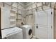 Bright laundry room with Bosch washer/dryer, built-in shelving, and overhead wire racks at 519 Via Garofano Ave, Henderson, NV 89011