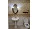 Cozy half-bathroom featuring decorative wallpaper, an oval mirror with vanity lights, and a pedestal sink at 5554 Chicory Falls Ct, Las Vegas, NV 89148