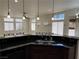 Open kitchen with an extended breakfast bar offering sink, granite countertops and large windows providing natural light at 5554 Chicory Falls Ct, Las Vegas, NV 89148