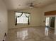Bright living room featuring tile flooring, large windows, and a ceiling fan at 5554 Chicory Falls Ct, Las Vegas, NV 89148