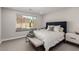 Bright bedroom featuring a large window with views of the landscaped backyard and comfortable upholstered bed at 59 Desert Ivy Ln, Henderson, NV 89011
