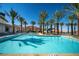 Large community pool features lounge chairs and picnic tables, surrounded by palms at 59 Desert Ivy Ln, Henderson, NV 89011