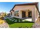 Home's exterior featuring backyard with patio, stone landscaping, and artificial turf at 59 Desert Ivy Ln, Henderson, NV 89011