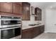Close up on kitchen featuring modern appliances, sleek cabinetry, and countertop with marble backsplash at 59 Desert Ivy Ln, Henderson, NV 89011