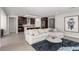 Open-concept living room featuring a plush sectional sofa, accent rug and views into the modern kitchen at 59 Desert Ivy Ln, Henderson, NV 89011