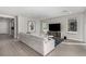 Open living room with views of kitchen, a large sectional, neutral colors, and wood-look tile flooring at 59 Desert Ivy Ln, Henderson, NV 89011