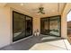 A covered patio with tile flooring features sliding glass doors and ceiling fan at 59 Desert Ivy Ln, Henderson, NV 89011