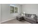 Comfortable sitting area featuring plush gray sofa and a view of the landscaped yard at 59 Desert Ivy Ln, Henderson, NV 89011