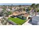 Spacious backyard featuring synthetic grass, desert landscaping, and a covered patio at 6520 Ouida Way, Las Vegas, NV 89108