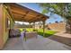 Backyard patio with covered sitting area and artificial turf lawn at 6520 Ouida Way, Las Vegas, NV 89108