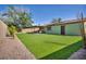 A well-manicured backyard boasts artificial turf and a covered patio for outdoor enjoyment at 6520 Ouida Way, Las Vegas, NV 89108