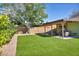 A charming backyard features a covered patio and a spacious artificial turf lawn at 6520 Ouida Way, Las Vegas, NV 89108