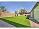 This backyard is completely covered in artificial turf with a covered patio, perfect for outdoor relaxation at 6520 Ouida Way, Las Vegas, NV 89108