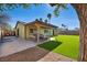 Beautiful backyard with artificial turf, covered patio, and outdoor seating area at 6520 Ouida Way, Las Vegas, NV 89108