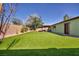 Artificial turf covers the entire backyard, and a covered patio provides shade for outdoor relaxation at 6520 Ouida Way, Las Vegas, NV 89108