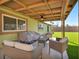 This covered patio features an outdoor dining area and artificial turf lawn at 6520 Ouida Way, Las Vegas, NV 89108