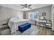 Cozy bedroom features a plush bed, blue ottoman, and vanity area, with a neutral color scheme and natural light at 6520 Ouida Way, Las Vegas, NV 89108