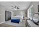 Comfortable bedroom features large bed, gray walls, fan, vanity area and lots of natural light at 6520 Ouida Way, Las Vegas, NV 89108