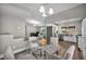 Contemporary dining space with glass table open to the kitchen and living room, showcasing a bright and inviting layout at 6520 Ouida Way, Las Vegas, NV 89108