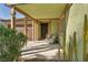 Charming front porch with desert landscaping, a comfortable wicker chair, and attractive architectural details at 6520 Ouida Way, Las Vegas, NV 89108