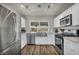 Well-lit kitchen boasts stainless steel appliances, white cabinetry, farmhouse sink and laminate flooring at 6520 Ouida Way, Las Vegas, NV 89108