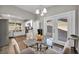Modern eat-in kitchen with stainless steel appliances, white cabinets, and a glass dining table set for four at 6520 Ouida Way, Las Vegas, NV 89108