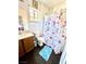 Cozy bathroom with wood-look tile flooring, a window, and a colorful mermaid shower curtain at 6819 Mahogany Meadows Ave, Las Vegas, NV 89122