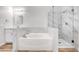 Bathroom showcasing tub, separate shower with glass door, and tiled walls at 689 Hitchen Post Dr, Henderson, NV 89011