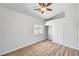 Bright bedroom with wood-look flooring, ceiling fan, and a closet with clothing rod at 689 Hitchen Post Dr, Henderson, NV 89011