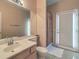 Bathroom featuring a sink, large mirror, shower with curtain, and an exterior door at 6971 Cedar Basin Ave, Las Vegas, NV 89142