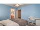 Comfortable bedroom featuring calming blue walls, bright lighting, and a dedicated workspace with modern furnishings at 6971 Cedar Basin Ave, Las Vegas, NV 89142