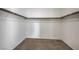Empty walk-in closet with wood rods for hanging clothes and carpeted floor at 6971 Cedar Basin Ave, Las Vegas, NV 89142