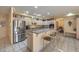 Bright open kitchen with a stainless steel refrigerator, granite countertops, and a breakfast bar with seating at 6971 Cedar Basin Ave, Las Vegas, NV 89142