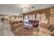 Bright living room featuring tile flooring, sophisticated window treatments, and elegant furnishings with a view of kitchen at 6971 Cedar Basin Ave, Las Vegas, NV 89142