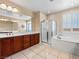 Bright bathroom features a double vanity, separate shower and tub, and plantation shutters at 6982 Mirkwood Ave, Las Vegas, NV 89178