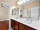 Bathroom with double vanity and mirrors offering ample lighting and counter space, and hardwood floors at 6982 Mirkwood Ave, Las Vegas, NV 89178