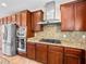 Kitchen featuring stainless steel appliances, granite countertops, custom cabinetry, and stainless hood at 6982 Mirkwood Ave, Las Vegas, NV 89178