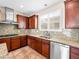 Well-lit kitchen with granite countertops, stainless steel appliances, custom cabinets, and tiled flooring at 6982 Mirkwood Ave, Las Vegas, NV 89178
