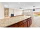 Open floor plan offering a fireplace, kitchen bar, ceiling fan, recessed lighting, and large sliding glass door at 6982 Mirkwood Ave, Las Vegas, NV 89178