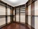 Spacious walk-in closet with custom shelves, hanging rods, and dark wood flooring at 6982 Mirkwood Ave, Las Vegas, NV 89178