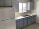 Kitchen featuring gray cabinets, a stainless steel sink, and a white refrigerator at 709 Scholl Dr, Las Vegas, NV 89107