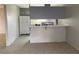 Bright kitchen area with a breakfast bar, tile flooring, and a full-size refrigerator at 709 Scholl Dr, Las Vegas, NV 89107