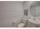 Neutral half bath featuring a pedestal sink, toilet, and decorative artwork at 757 Omaggio Pl, Henderson, NV 89011