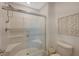 Bright white bathroom with glass shower doors, handheld shower head and geometric decorative art on the wall at 757 Omaggio Pl, Henderson, NV 89011