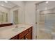 Bright bathroom featuring a single sink vanity, a large mirror, and a glass enclosed shower at 757 Omaggio Pl, Henderson, NV 89011