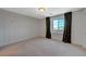 Bedroom with neutral carpet, light gray walls, and a window with dark curtains at 757 Omaggio Pl, Henderson, NV 89011