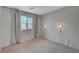 Bright, light-filled bedroom features a window with gray curtains, modern lighting and carpeting at 757 Omaggio Pl, Henderson, NV 89011