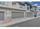A view of the property's well-maintained exterior and gray garages with stone accents and pavers at 757 Omaggio Pl, Henderson, NV 89011